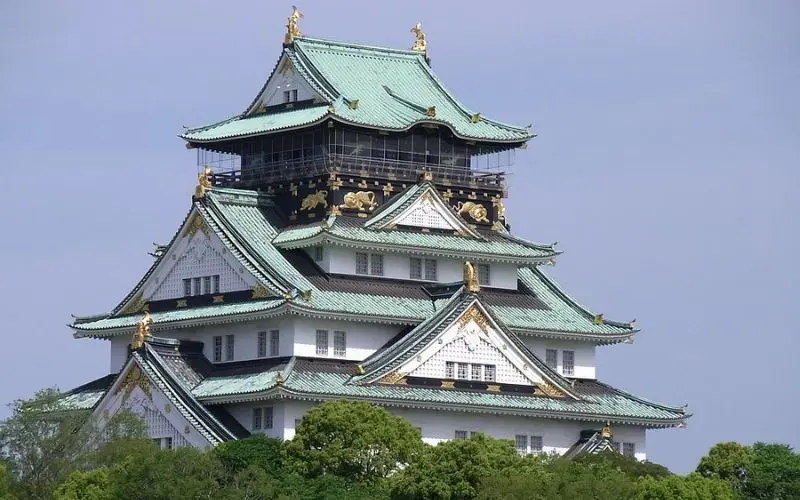 Osaka Castle in Japan features white walls, green roofs, and golden details.