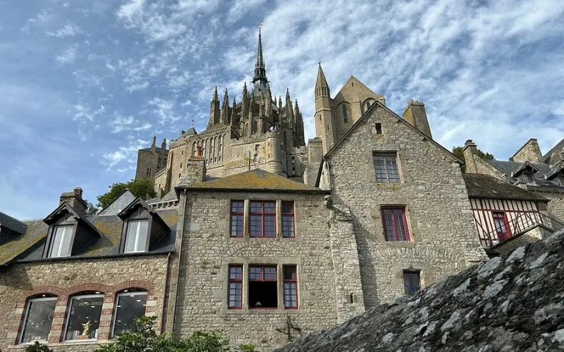 Mont Saint-Michel in France rises above stone houses with a tall spire.
