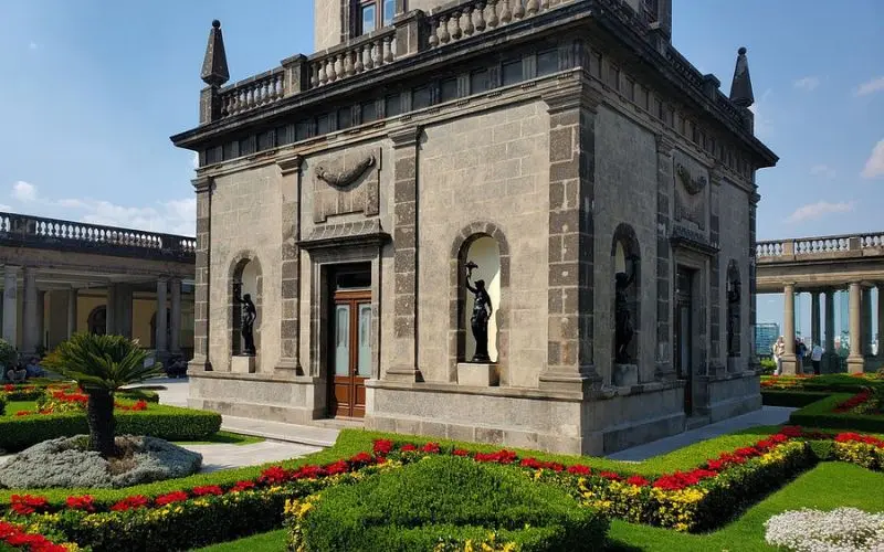 Chapultepec Castle in Mexico has stone walls, statues, and colorful gardens.