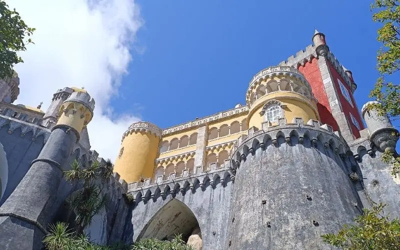 The National Palace of Pena in Portugal shows colorful red and yellow towers.