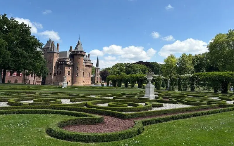 De Haar Castle in the Netherlands is surrounded by gardens and trimmed hedges.