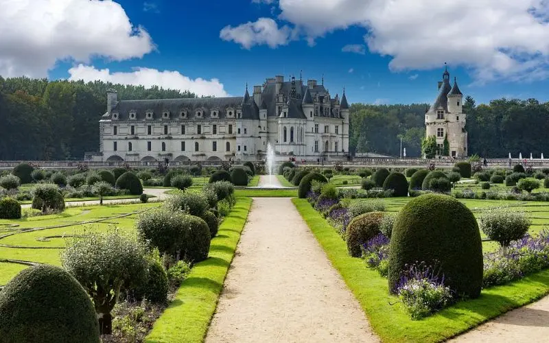 Château de Chenonceau in France stretches across a river with formal gardens.