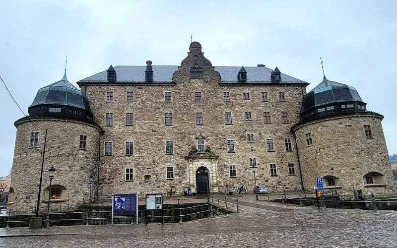 Örebro Castle in Sweden with round towers and a stone facade.
