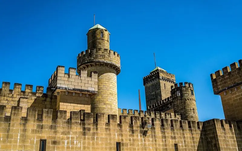Sunshine Castle in Australia with tan stone towers and battlements against a clear blue sky.