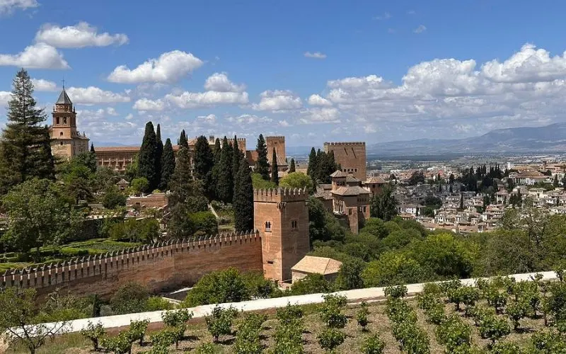 The Alhambra in Spain overlooks Granada with towers, gardens, and distant mountains.