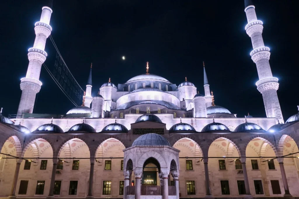 A low-angle night view of the illuminated Blue Mosque