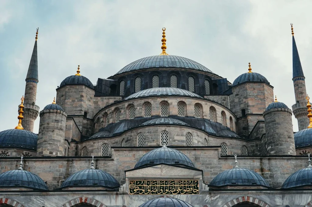 Close-up of the Blue Mosque's domes and minarets under a cloudy sky