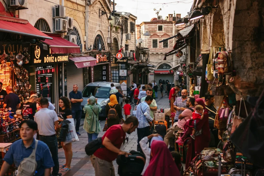 A busy stone-paved street market in Istanbul crowded with people