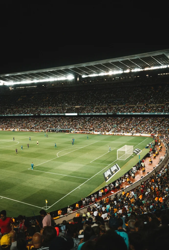 Packed football stadium stands under bright lights during a night match at Camp Nou in Barcelona