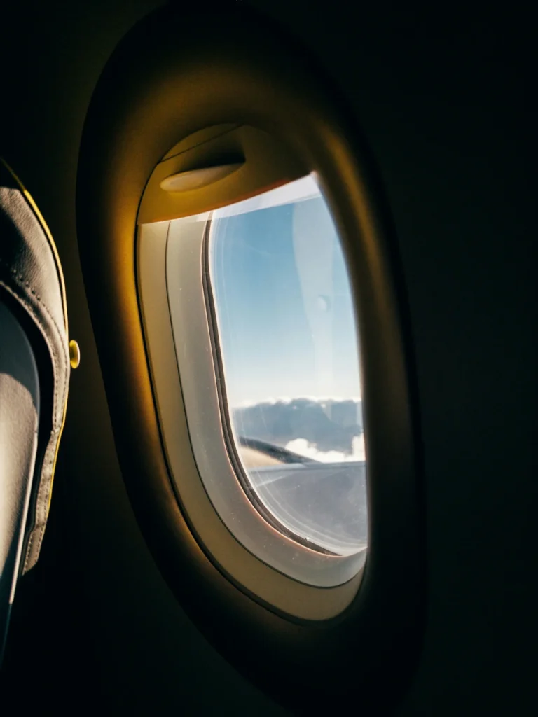 Airplane window view looking out at the sky above clouds from a Ryanair seat