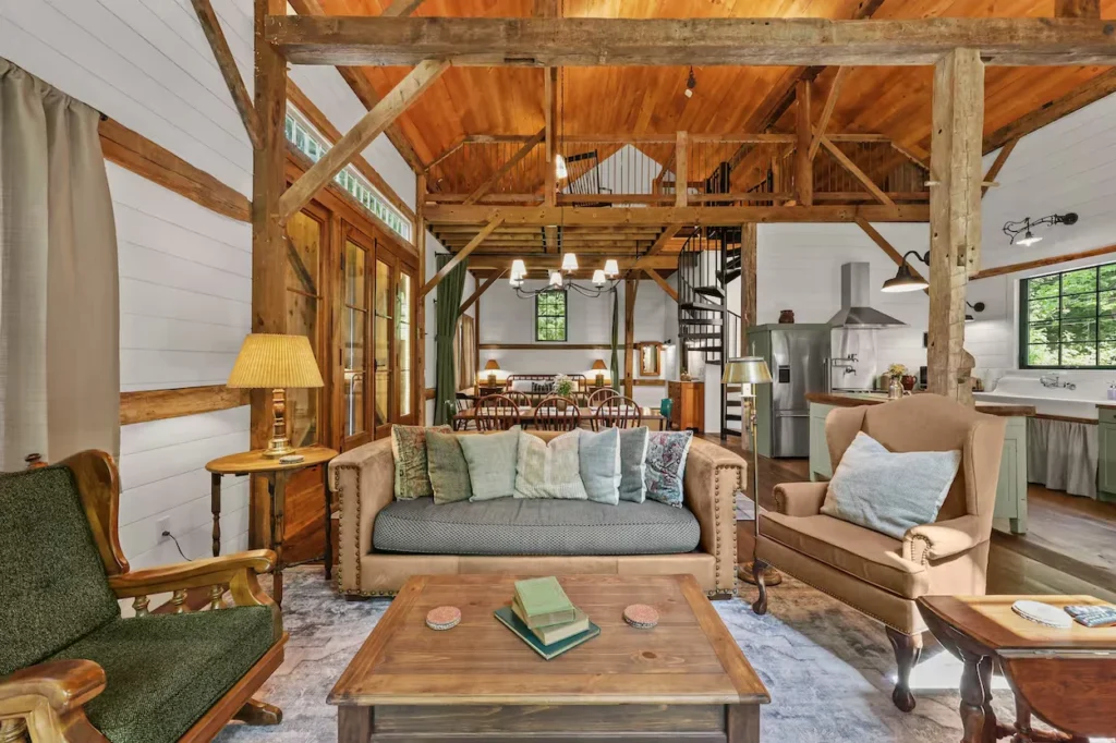 Rustic living room inside a converted barn with exposed wood beams and white walls