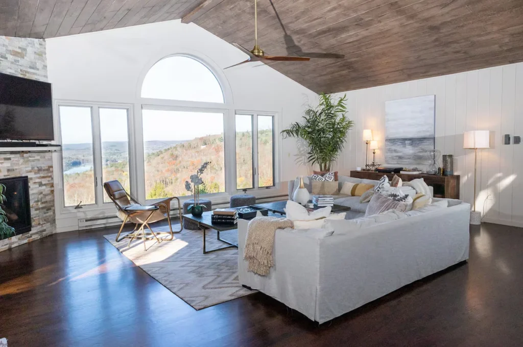 Modern rustic living room with a large window overlooking hills