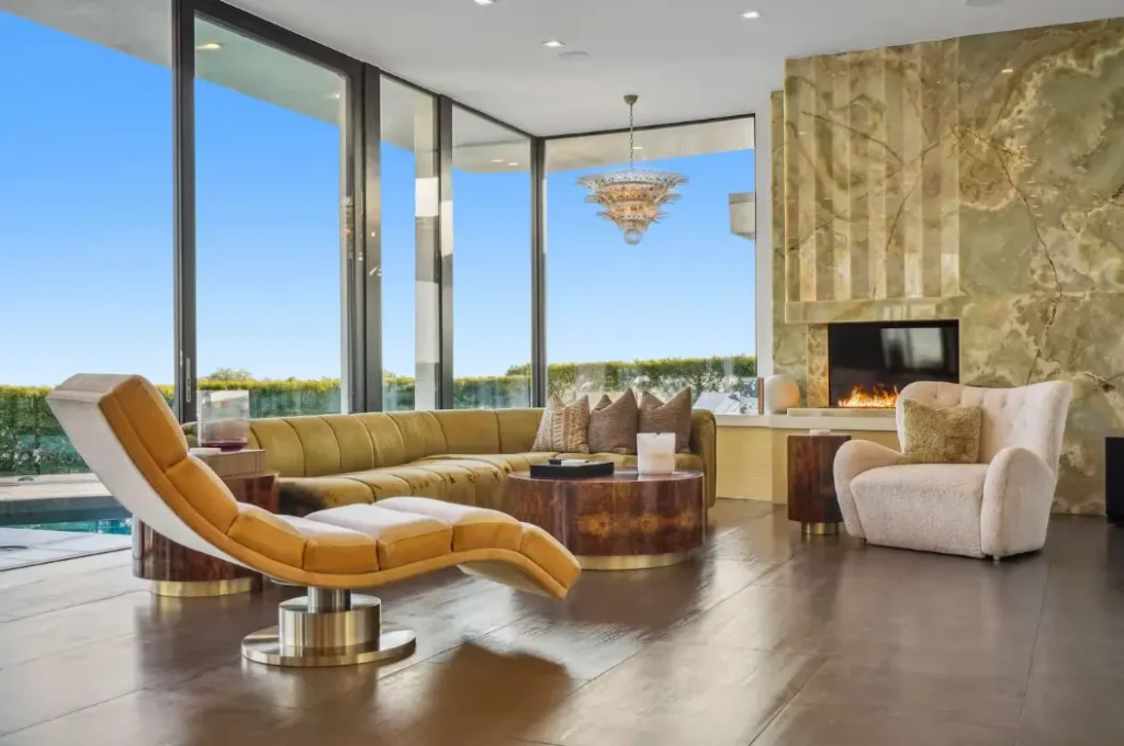 Plush seating, onyx fireplace, and expansive floor-to-ceiling windows with stunning views