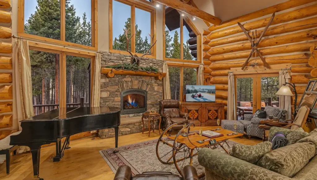 Great room with fireplace, TV, vintage gondola car, and deck access