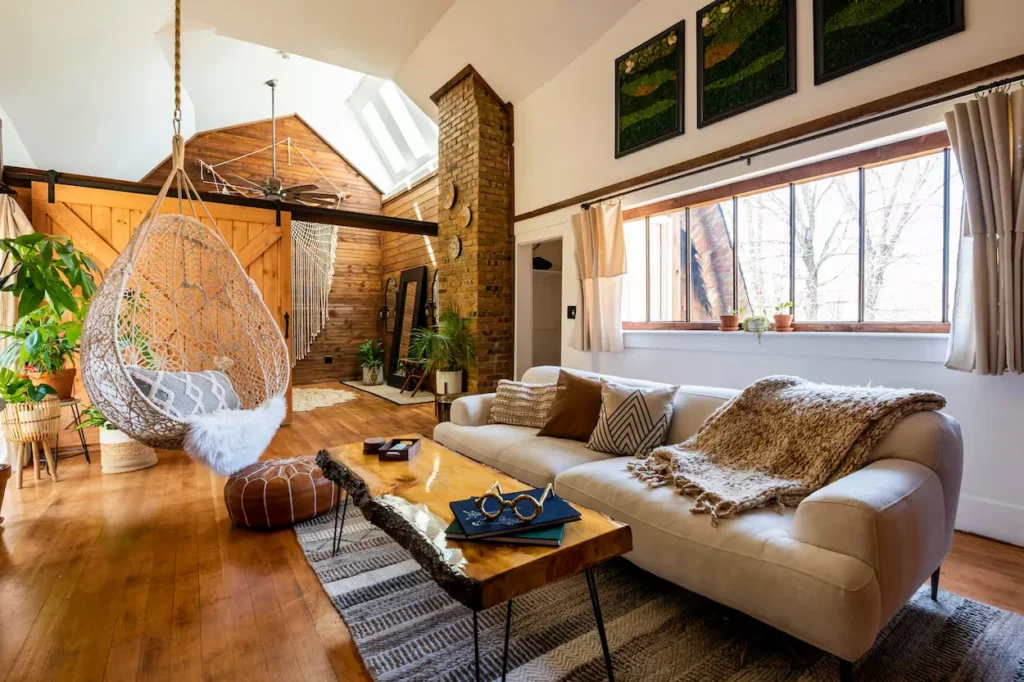 Boho living room with a macrame hanging chair, edge wood coffee table, and cream couch