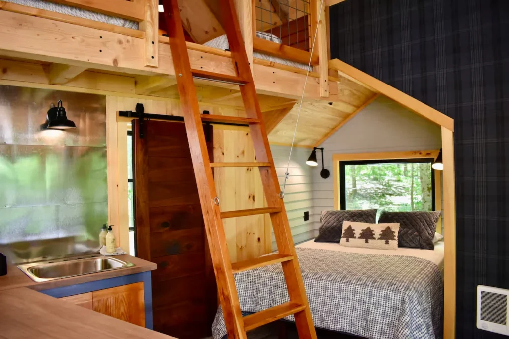 Wooden treehouse interior with a loft ladder and bedroom nook