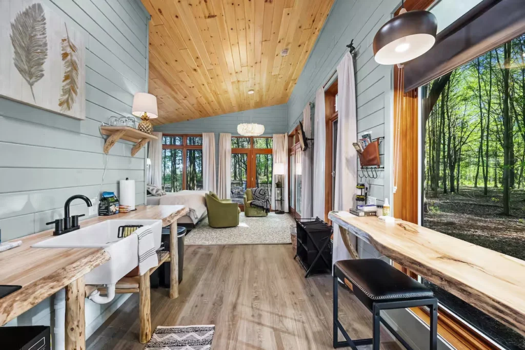 Open cabin interior with a live-edge counter and large window facing woods