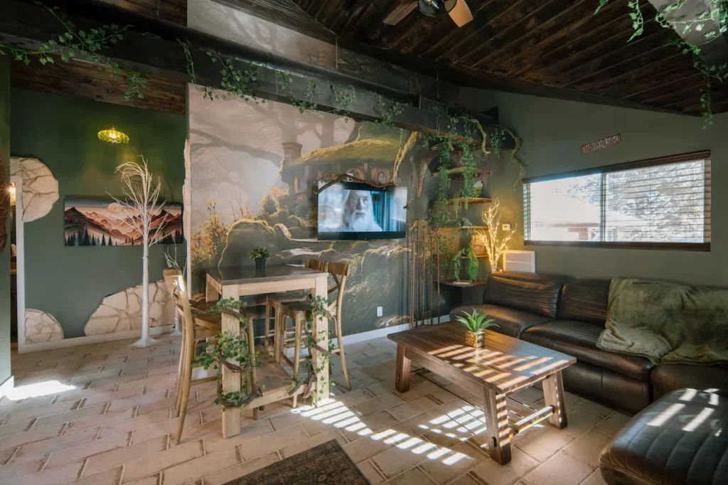 Lord of the Rings themed living room with a Hobbiton mural, green walls, and hanging vines
