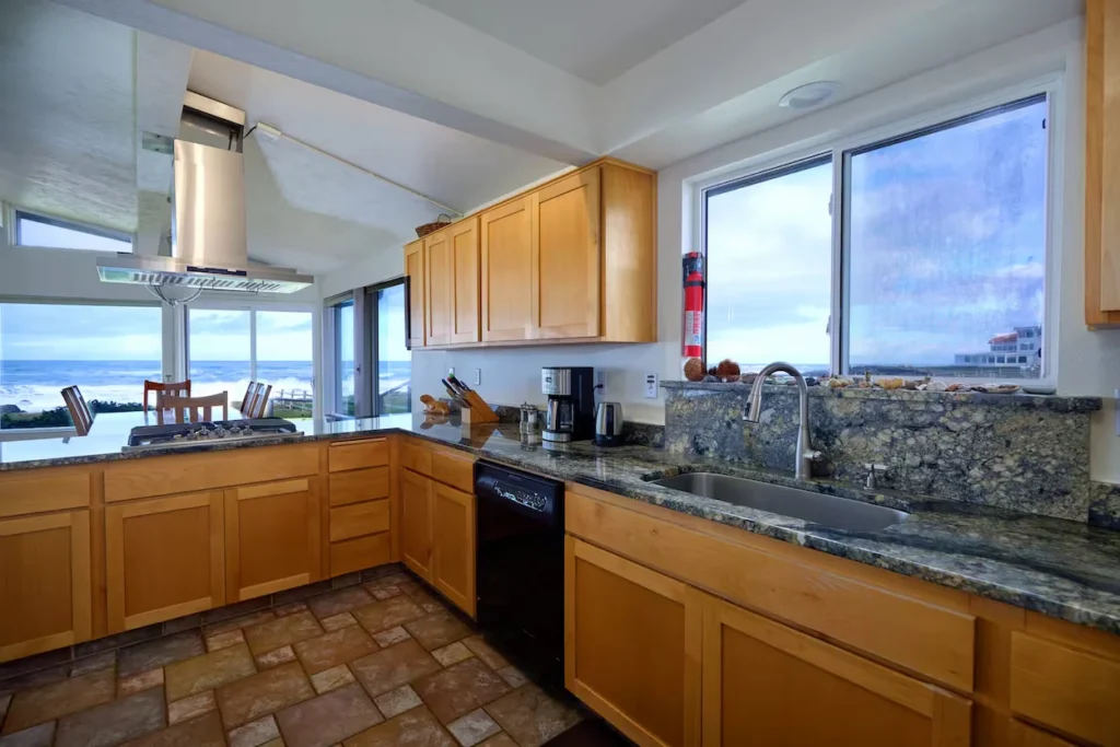 Cabin kitchen with wood cabinets and granite counters overlooking the sea