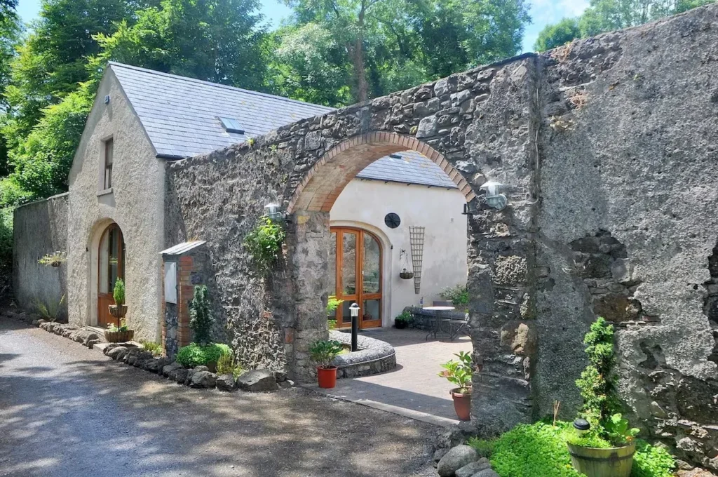 Historic stone cottage courtyard with a large archway leading to a private patio