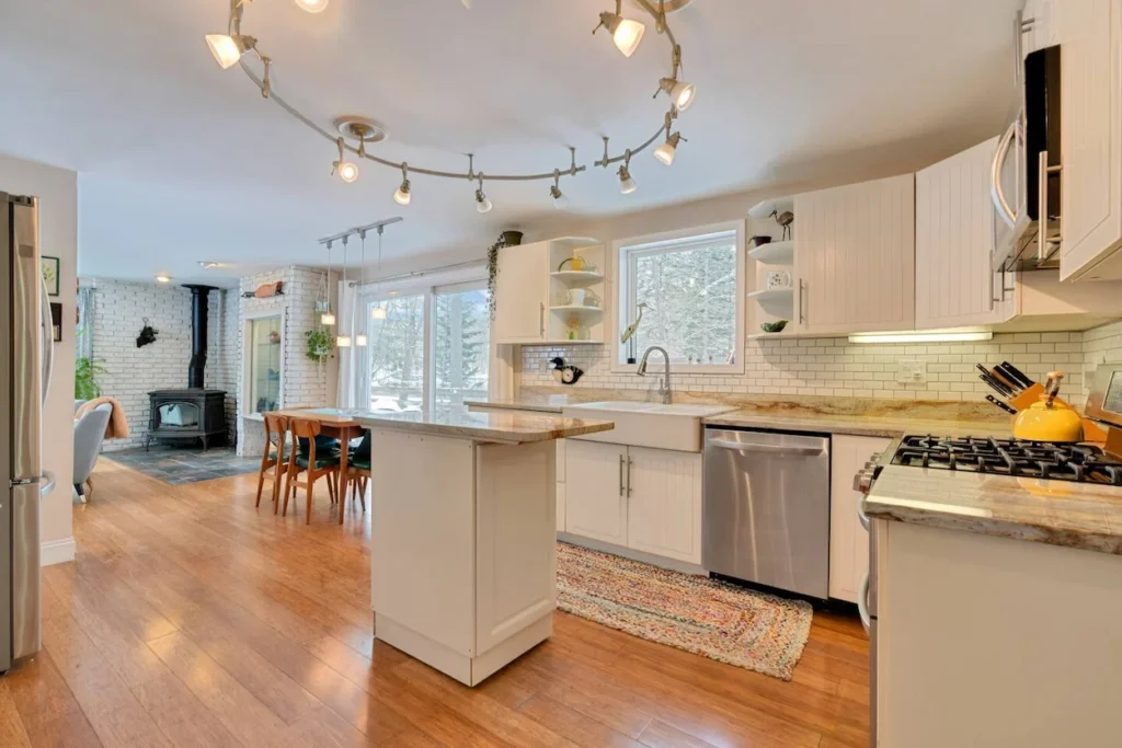 Bright open kitchen with white cabinets, a small island, and subway tile backsplash