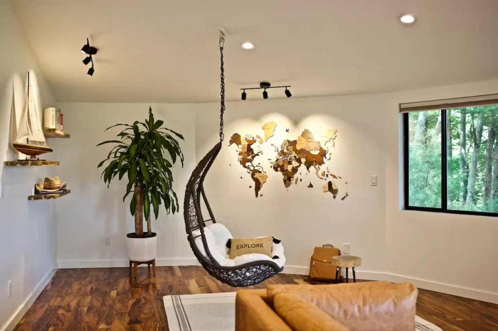 Modern cabin room with a hanging egg chair, wooden world map wall art, and a large houseplant