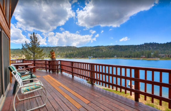 Large deck with chairs overlooking the lake at this lake house rental in California.