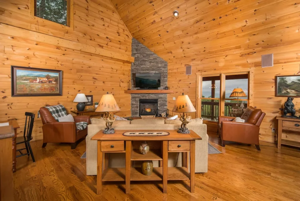 Pine living room with stone fireplace and brown leather chairs