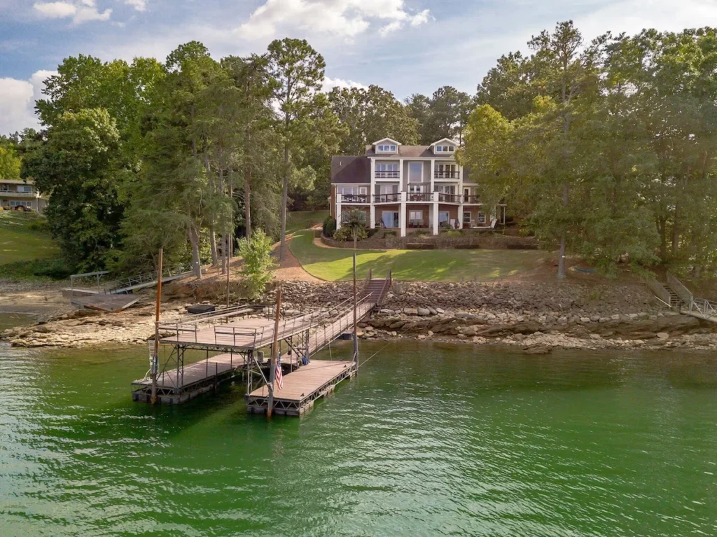 Waterfront mansion on Lake Lanier in Buford, Georgia, with a private wood dock and walkway leading to the shore