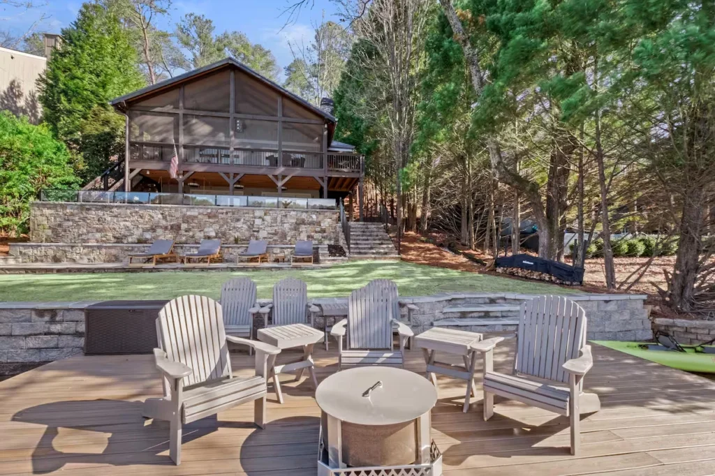 Lakefront cabin deck in Waleska, Georgia, with Adirondack chairs surrounding a central metal fire pit