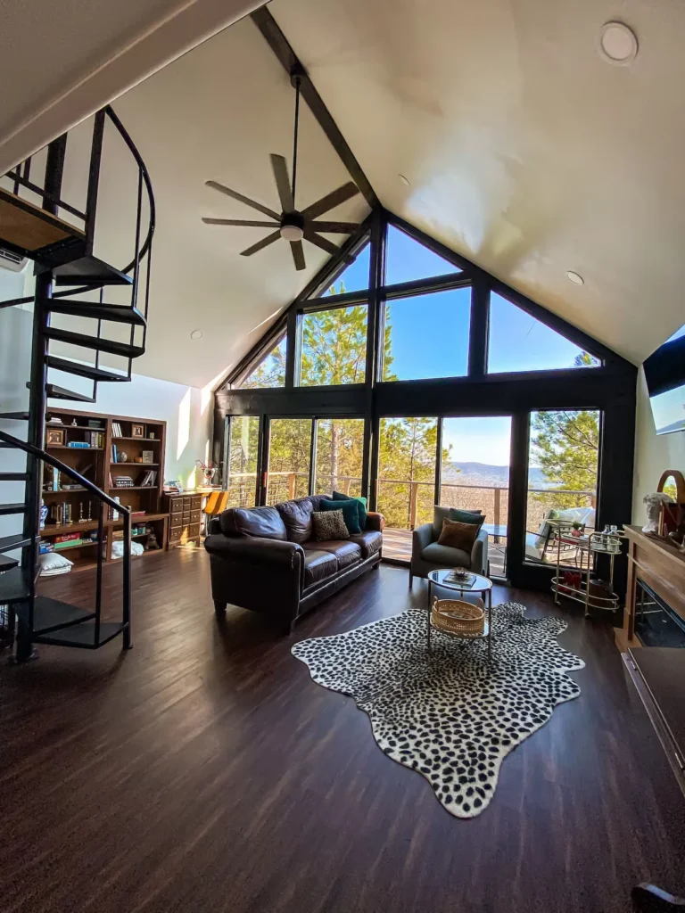 Hot Springs cabin living room with a spiral staircase and large wall of windows