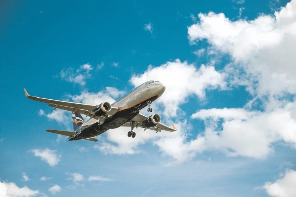 Low-angle view of an Aeroflot commercial airplane flying through a blue sky with white clouds