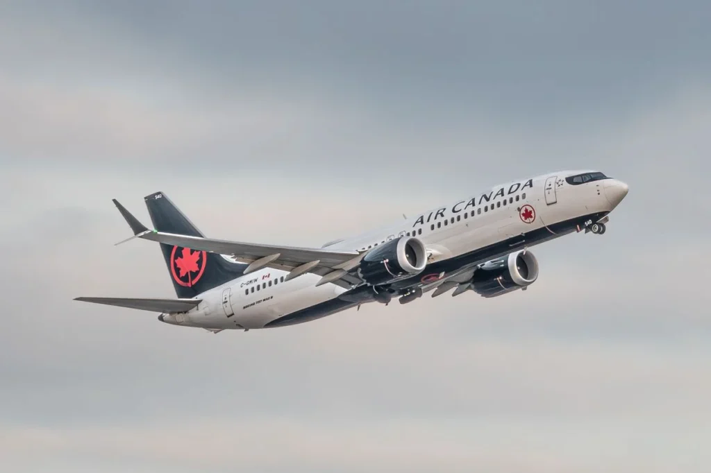 Air Canada Boeing 737 MAX airplane climbing into a cloudy sky