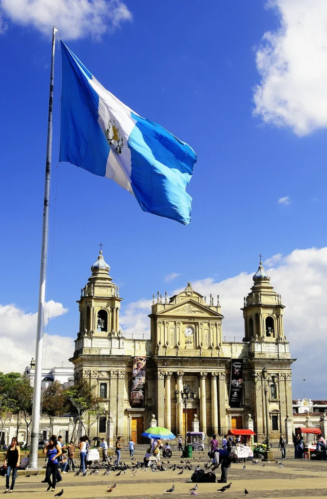 Guatemala flag waving in front of the historic Metropolitan Cathedral