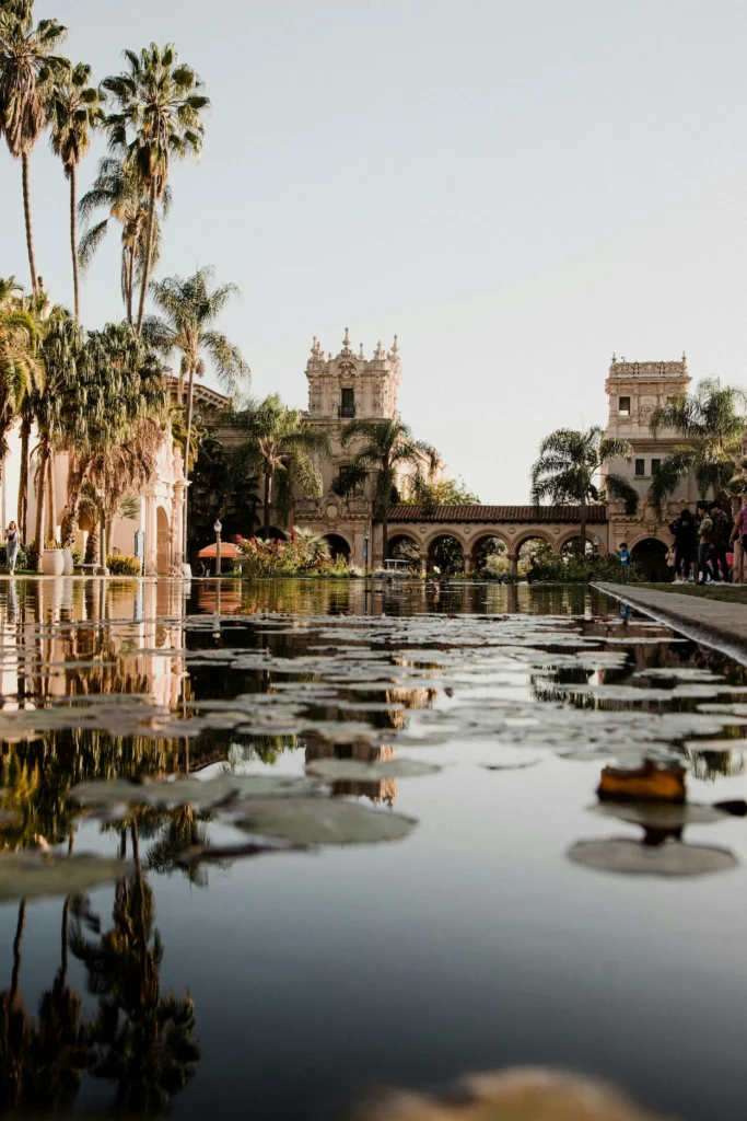 The Lily Pond in Balboa Park reflecting historic buildings and palm trees