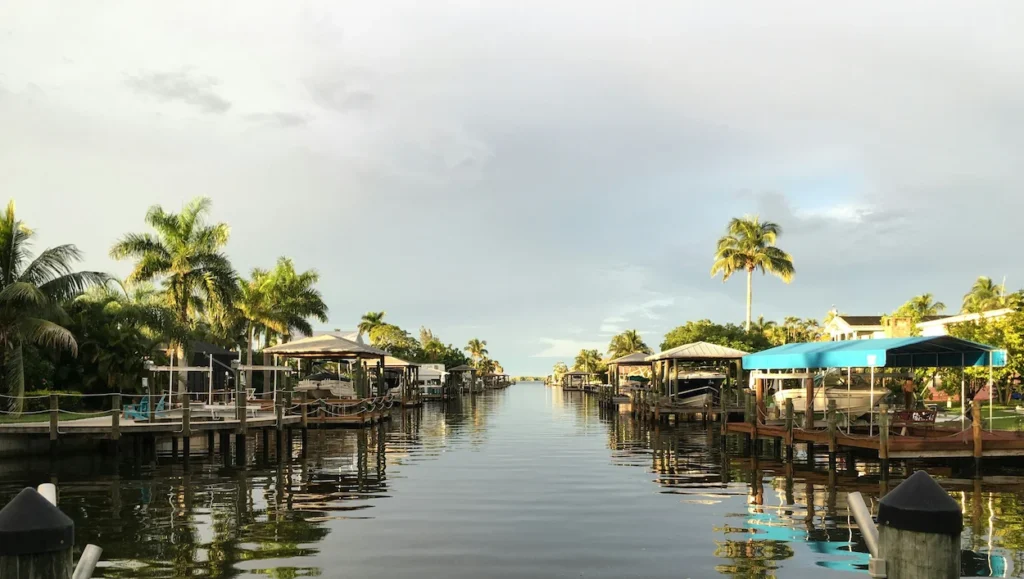 A residential boating canal lined with private docks and palm trees in Cape Coral, Florida