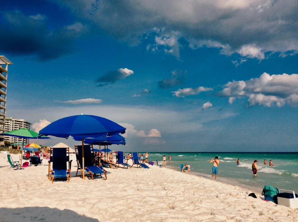 Blue beach umbrellas and lounge chairs on the white sand of Destin Beach in Florida