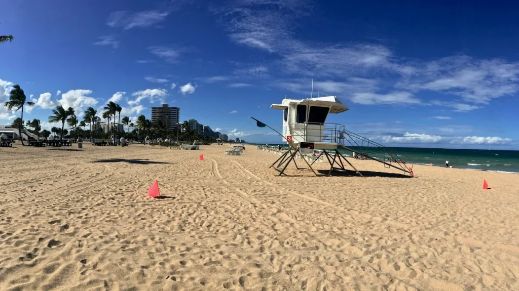 A white lifeguard tower on the wide sandy expanse of Fort Lauderdale Beach in Florida