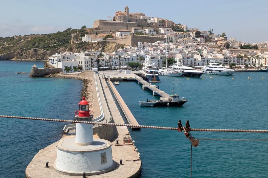 Ibiza harbor lighthouse with the hillside fortress city in the background