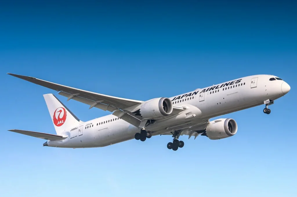 Japan Airlines Boeing 787 Dreamliner flying against a clear blue sky