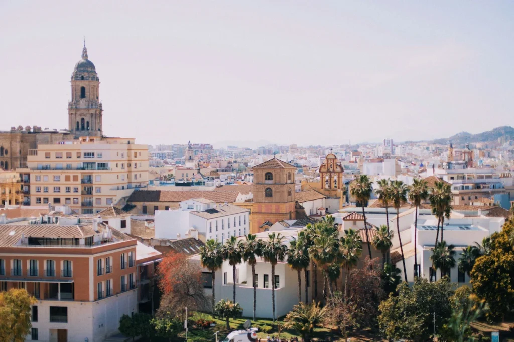 The Málaga Cathedral tower and historic city skyline with palm trees in Spain