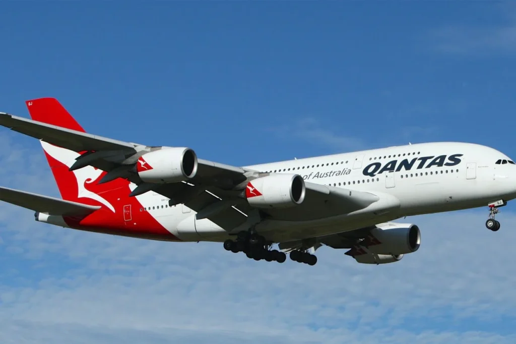 Qantas Airbus A380 double-decker aircraft descending against a blue sky