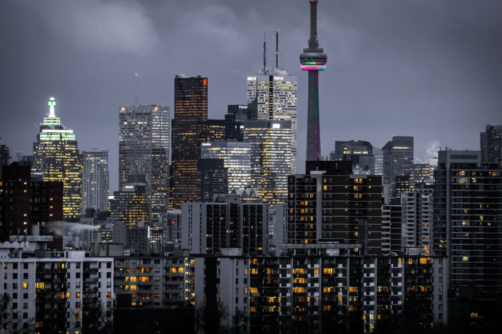 CN Tower piercing the night sky amidst the glowing skyscrapers of downtown Toronto