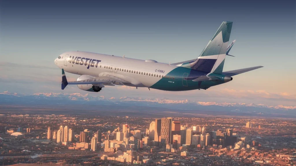 WestJet Boeing 737 MAX airplane flying over Calgary skyline