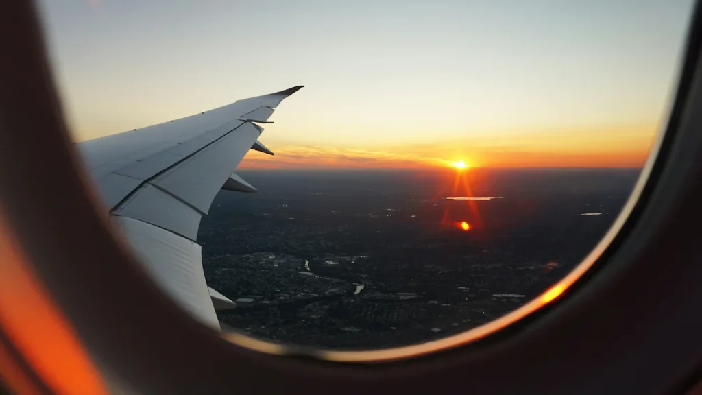 Sunset view from an airplane window over a city landscape