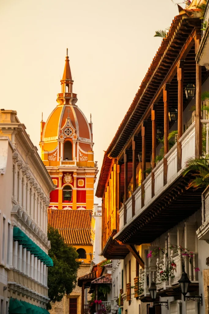 Cartagena Cathedral framed by historic buildings with wooden balconies at sunset