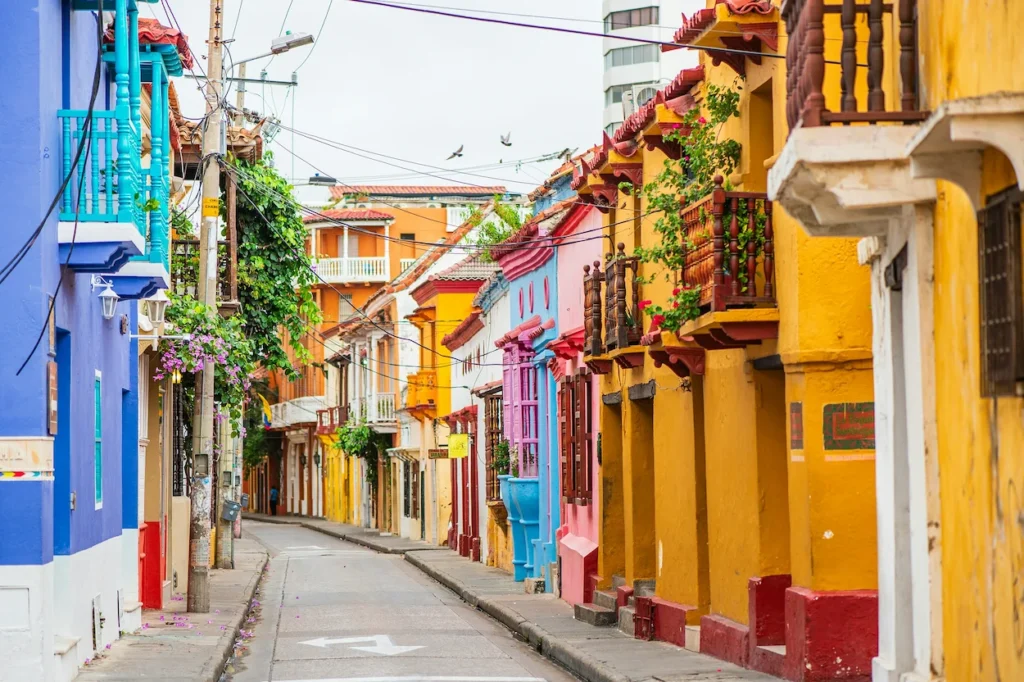 Narrow street with vibrant yellow, pink, and blue colonial houses in Cartagena
