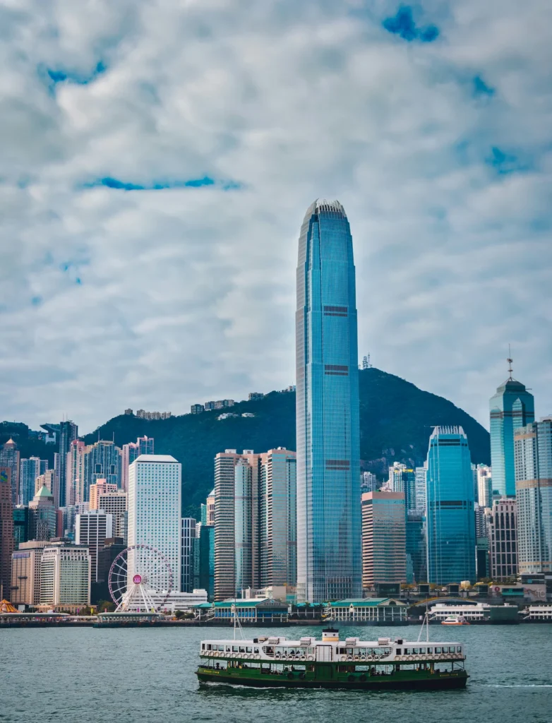 Green and white Star Ferry sailing past the International Finance Centre tower in Hong Kong