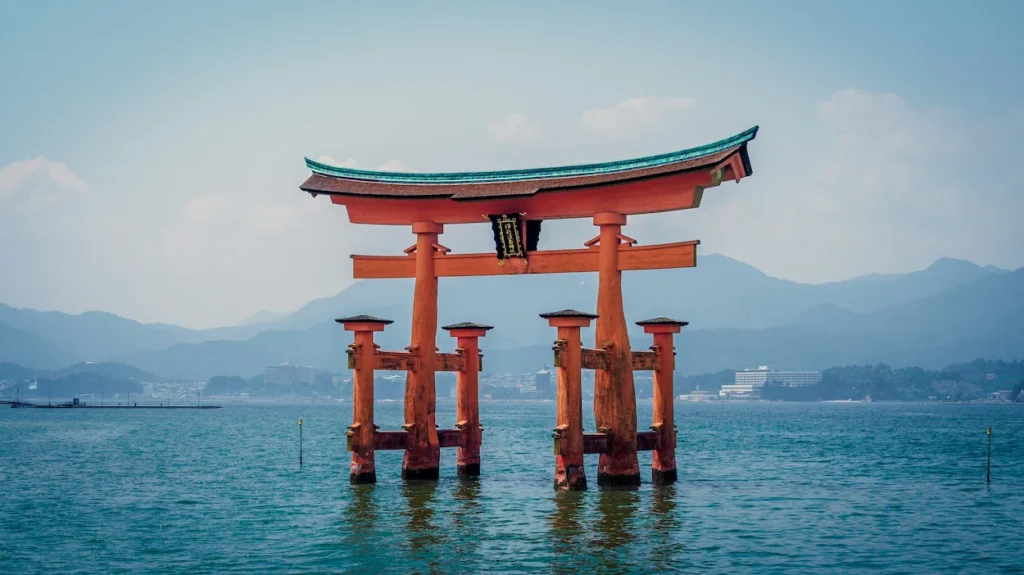The orange Itsukushima Shrine torii gate standing in the sea at Miyajima