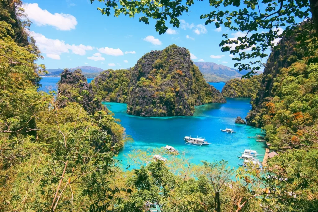 Boats anchored in the turquoise water of Kayangan Lake surrounded by limestone cliffs
